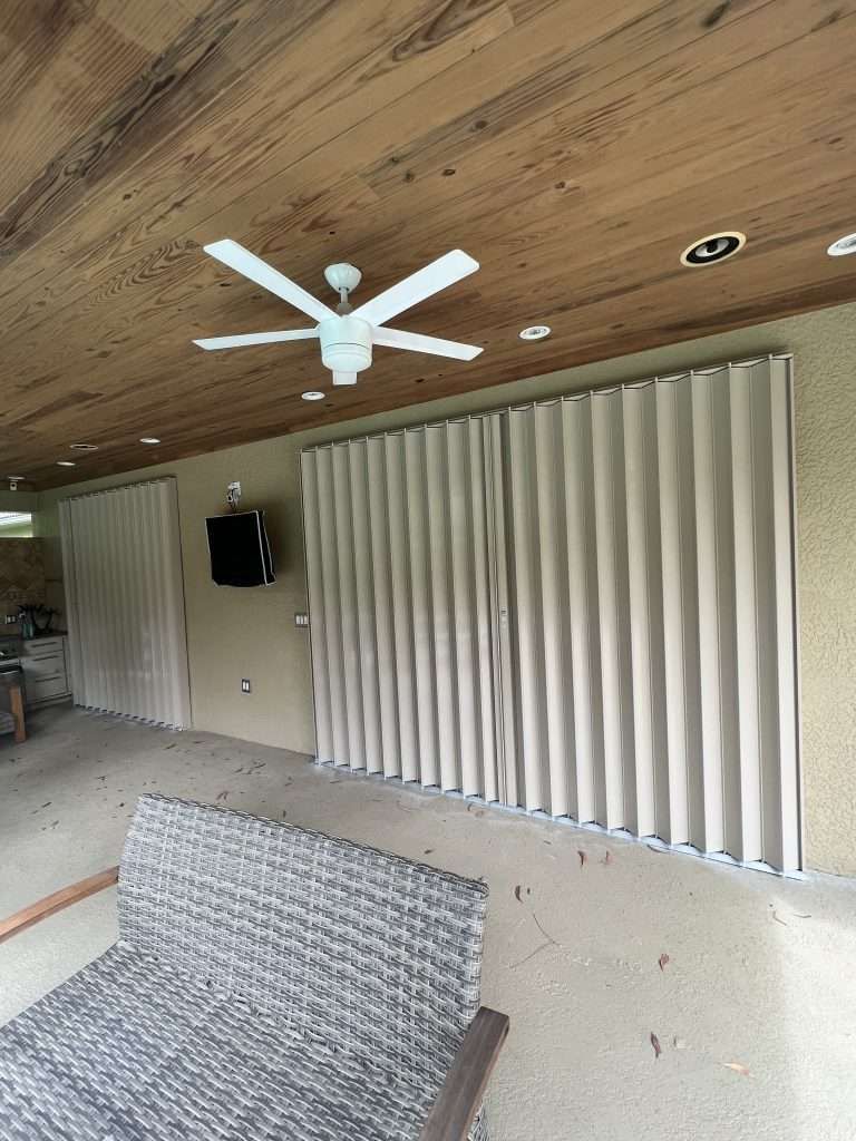 A Patio With Sliding Glass Doors and a Ceiling Fan — Naples, FL — Wind Safe Shutters LLC