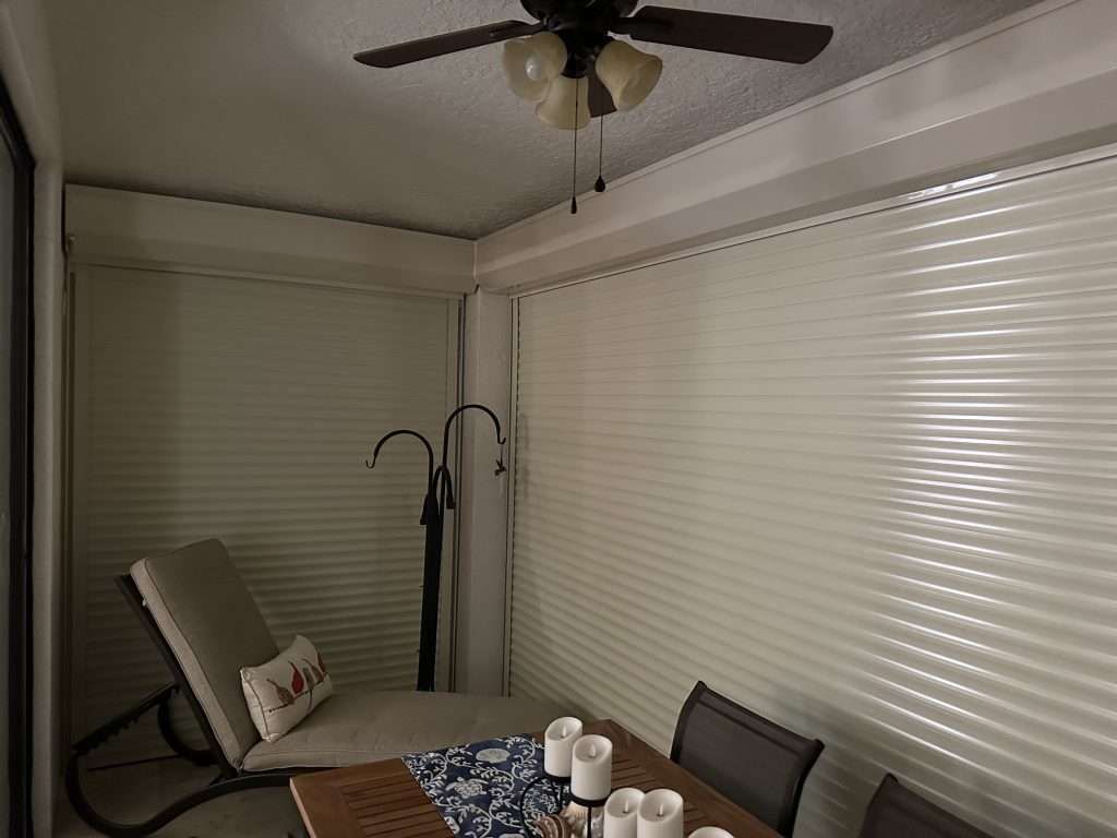 A Dining Room With a Table and Chairs and a Ceiling Fan — Naples, FL — Wind Safe Shutters LLC