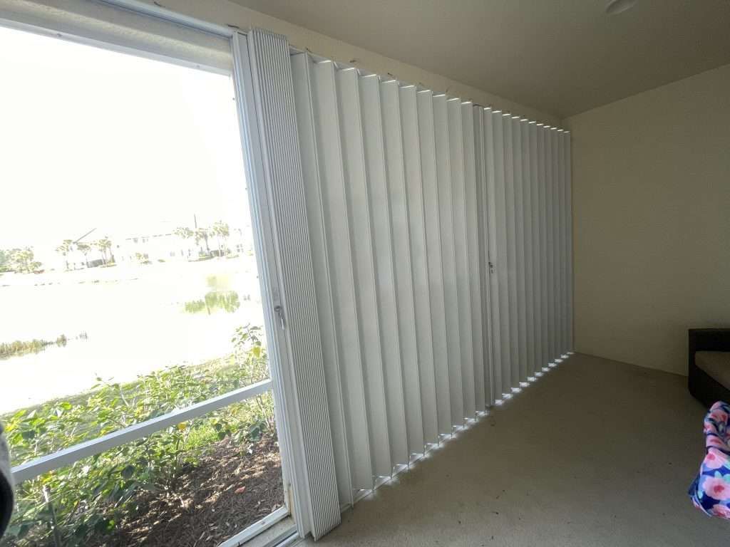 A Room With a Large Window and White Blinds — Naples, FL — Wind Safe Shutters LLC