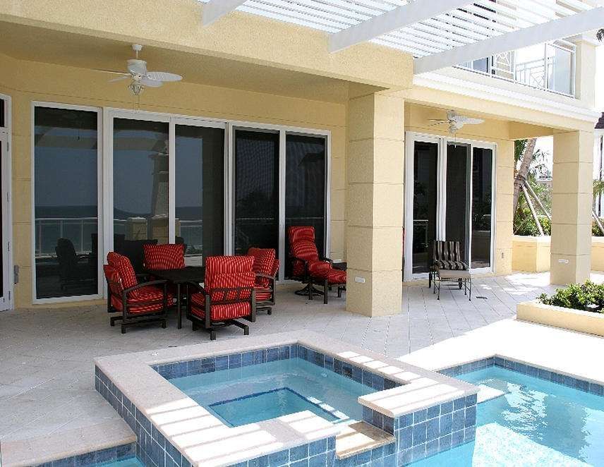 A Large House With a Swimming Pool and Patio Area — Naples, FL — Wind Safe Shutters LLC