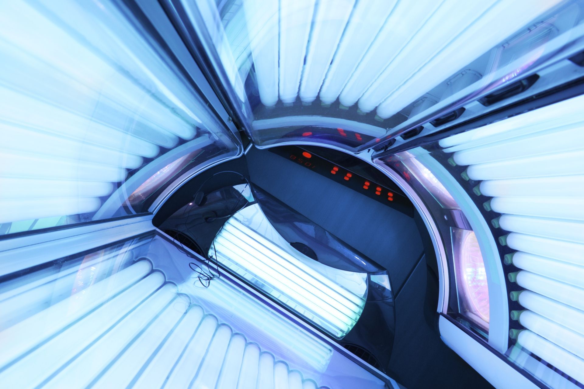 A woman in a bikini is getting a spray tan on her arm.