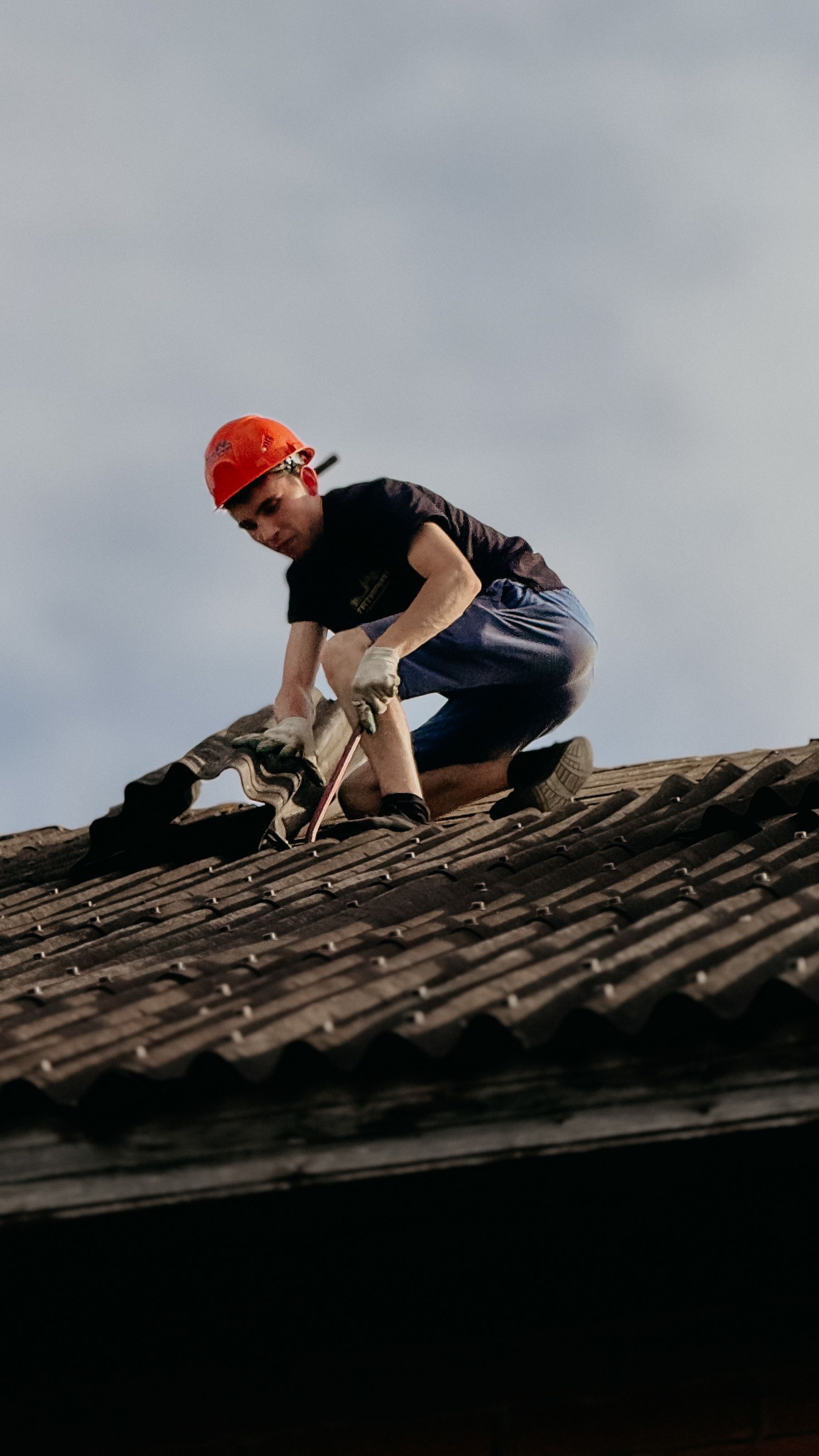 Roofer repairing damaged shingles after a storm