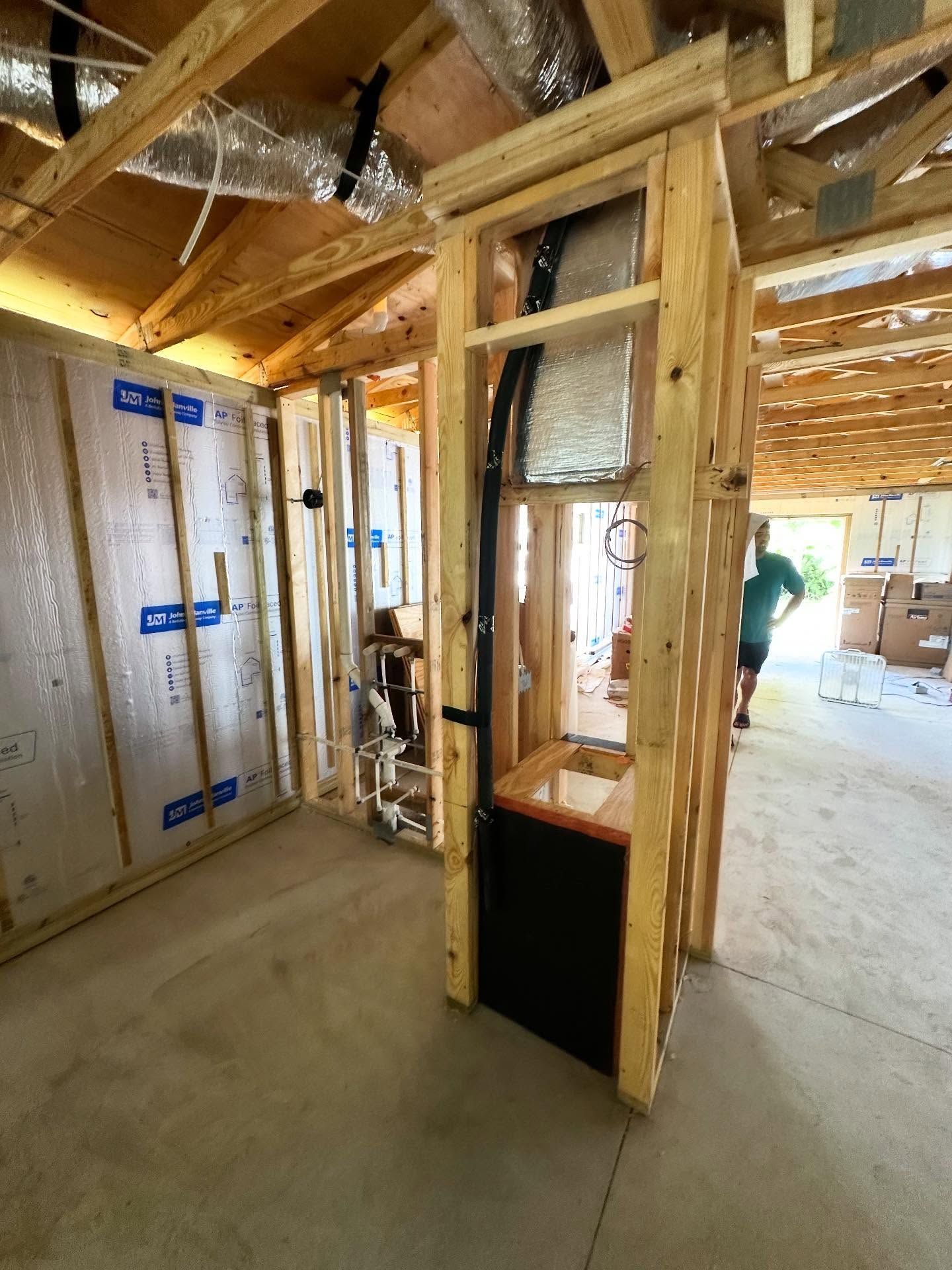Interior view of a bathroom under construction; exposed wooden framin