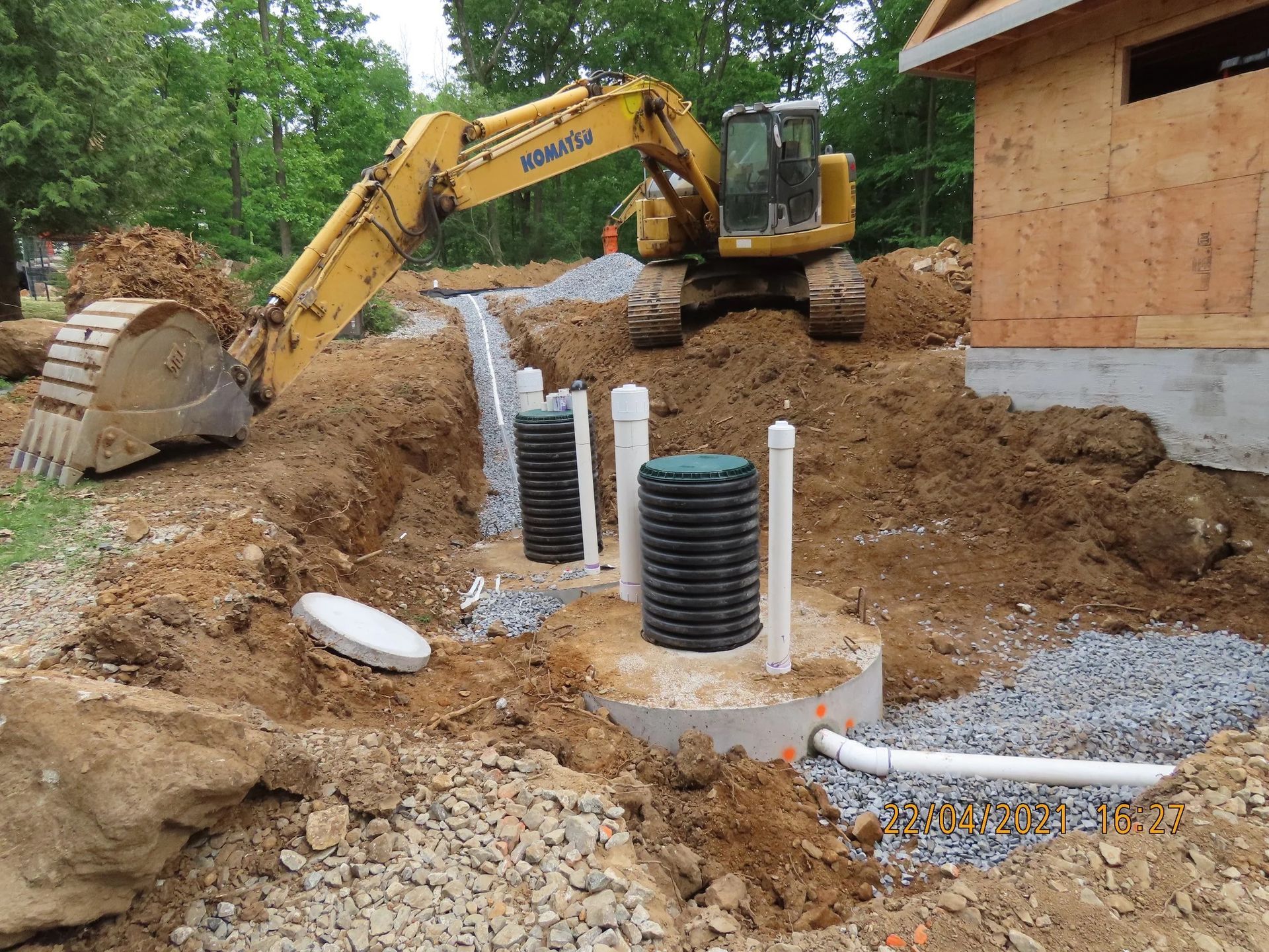 Excavator working on a construction site, installing a septic tank system.