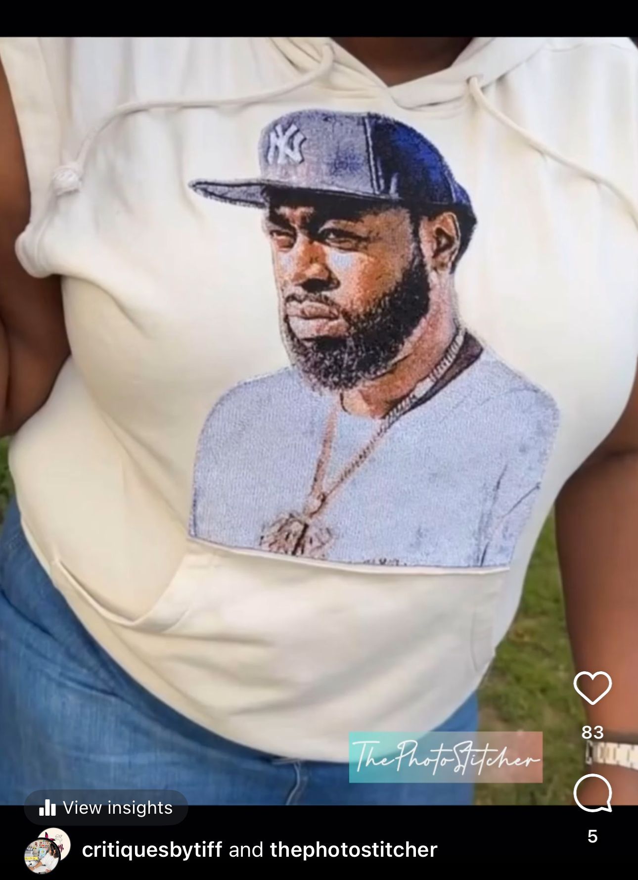 A woman is wearing a white hoodie with a picture of a man on it.
