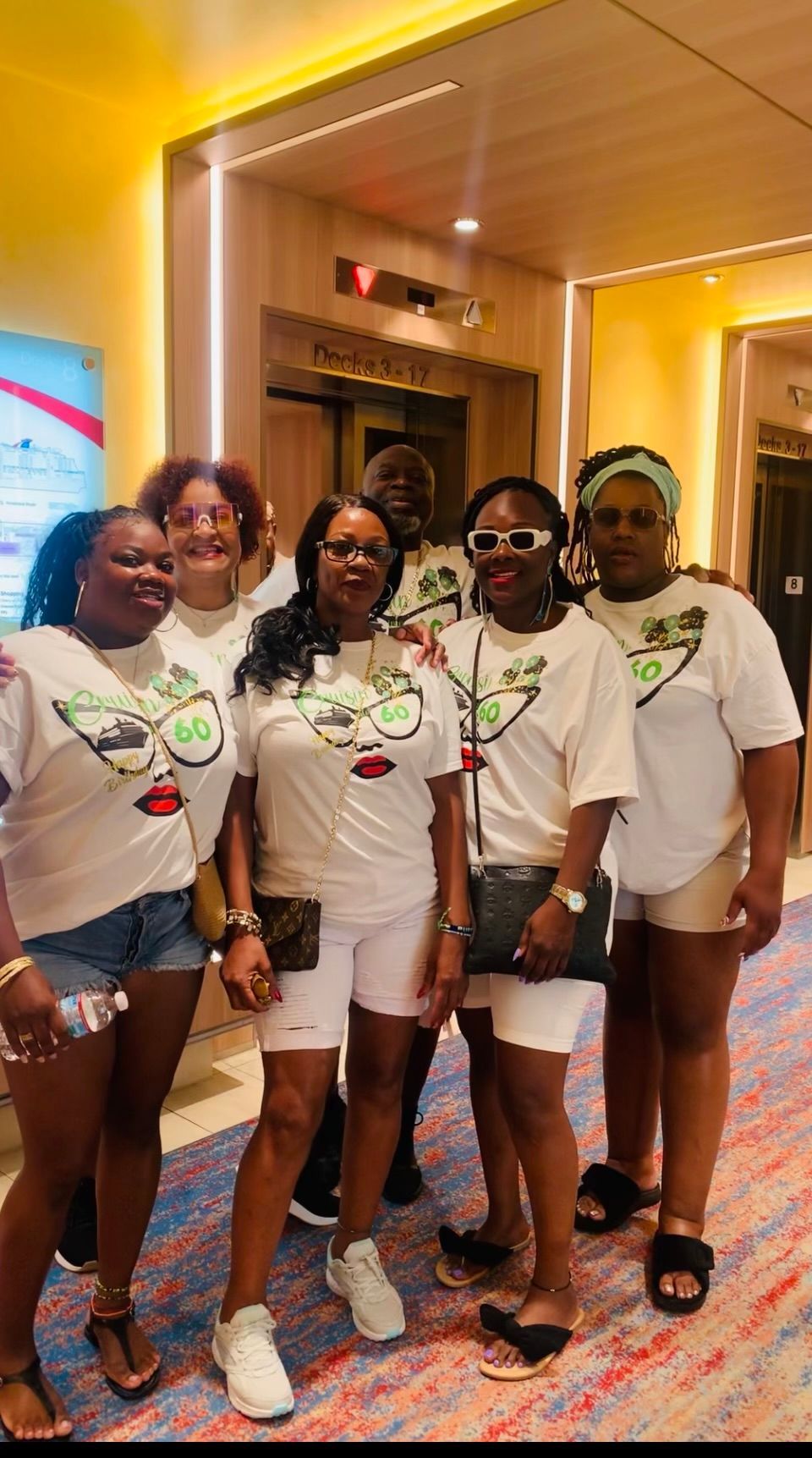 A group of women are posing for a picture in a hallway.