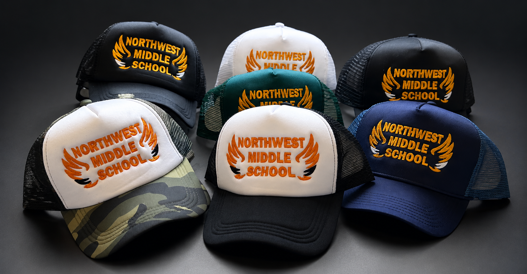Assorted NorthWest Middle School baseball caps in black, white, gray, and camo arranged in a studio display.