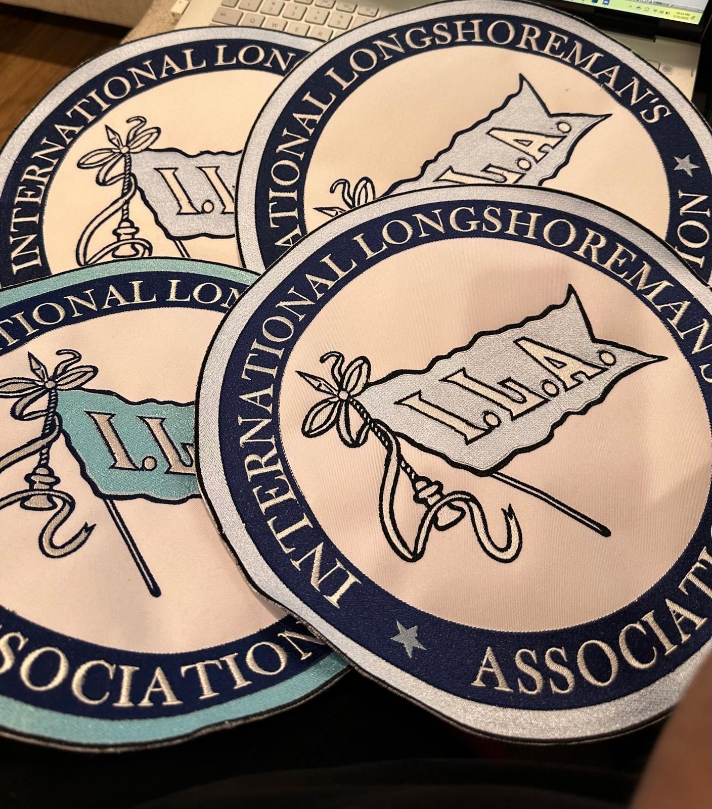 Four circular International Longshoremen's Association patches with blue and white lettering and flag logo.