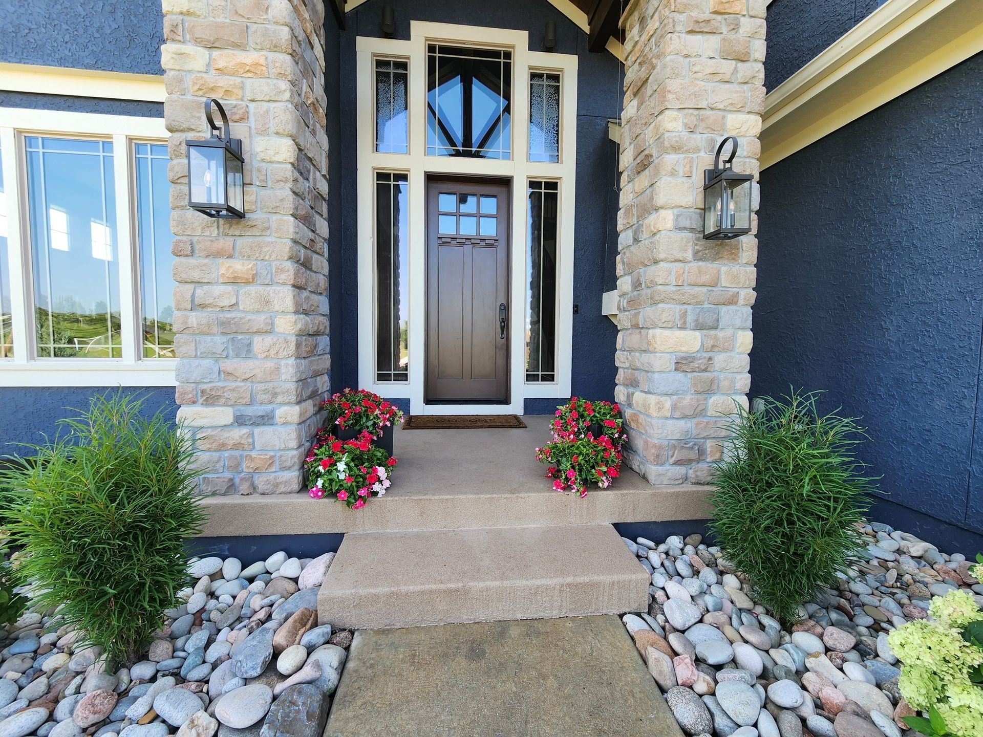 A blue house with a wooden door and a stone porch