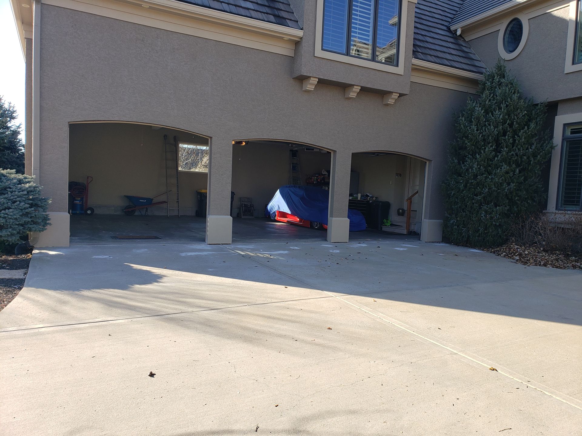 A car is parked in a garage next to a house.