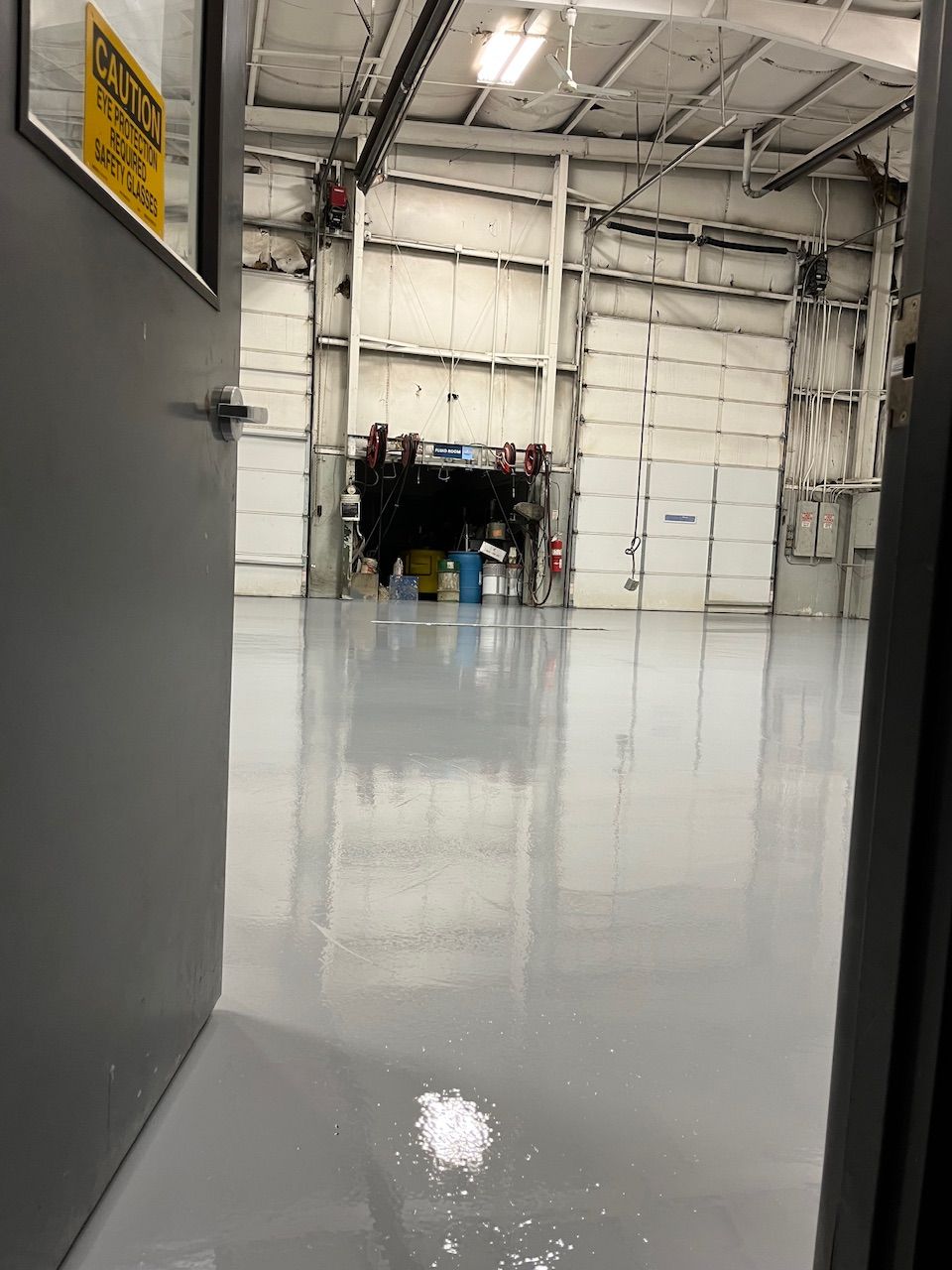 A warehouse with a yellow sign on the door that says caution