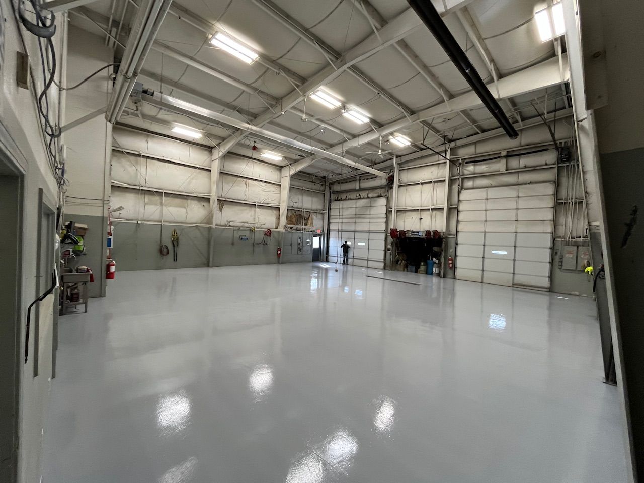 A large empty warehouse with a gray floor and white walls.