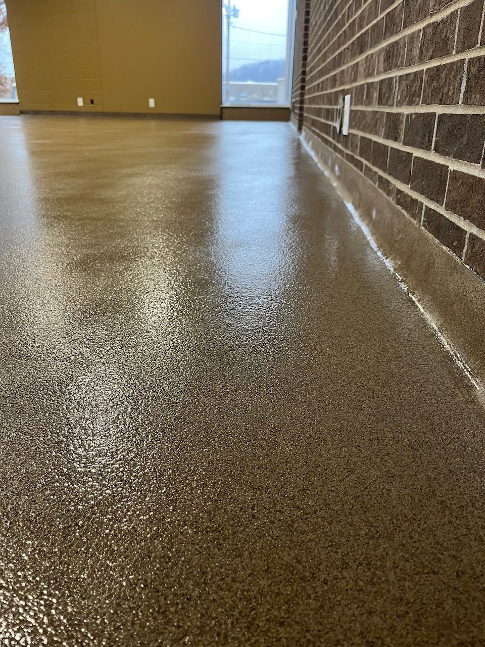 A room with a brick wall and a shiny floor.