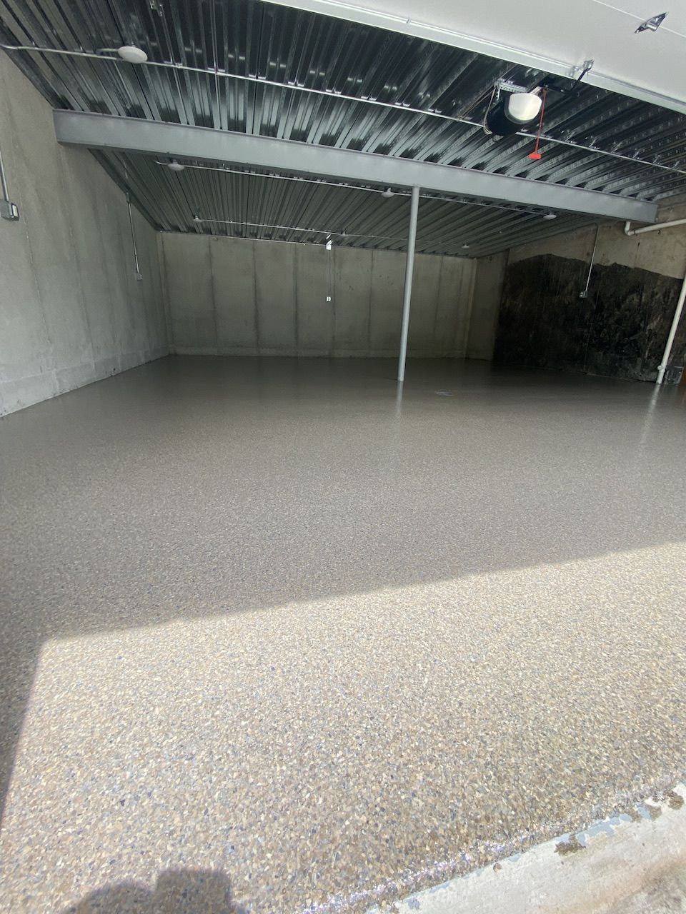 A garage with a concrete floor and a metal roof.