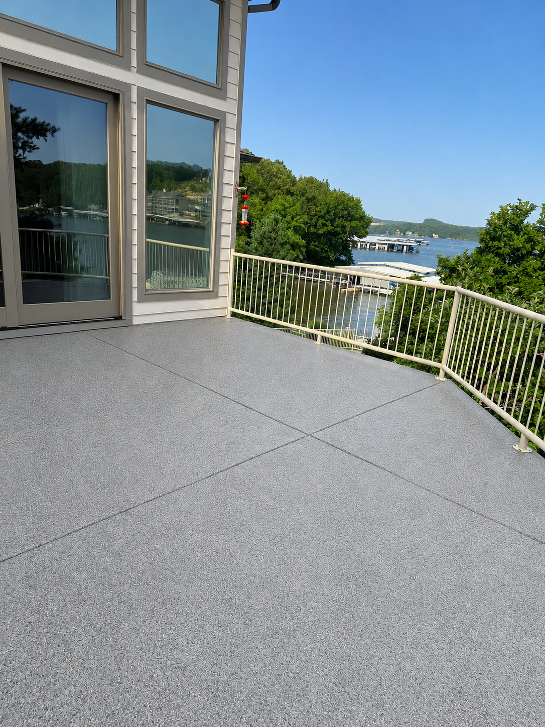 A porch with a screened in area and a concrete floor.
