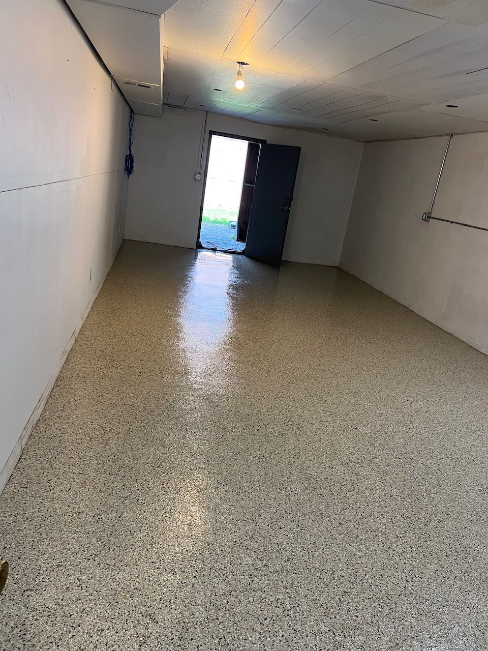 An empty room with a shiny floor and a door.