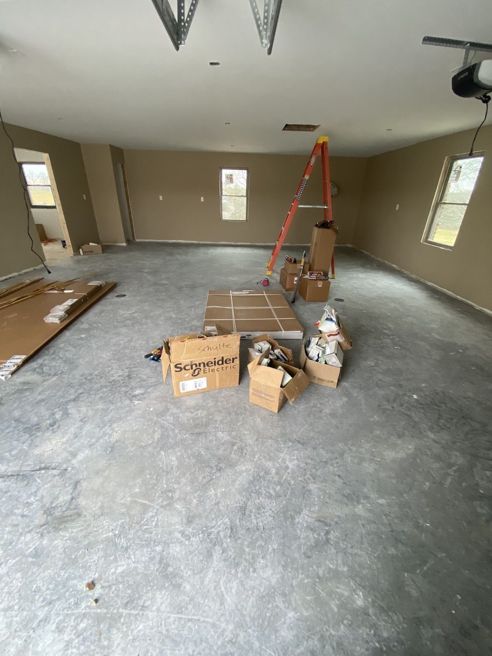 A large room with boxes and a ladder in it.