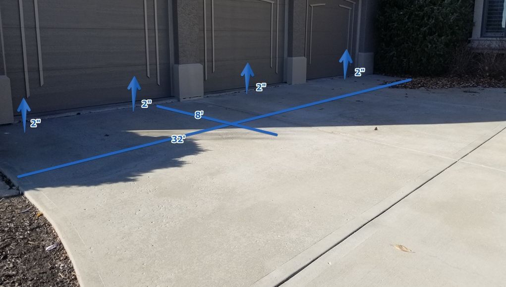 A concrete driveway with blue arrows pointing up and down