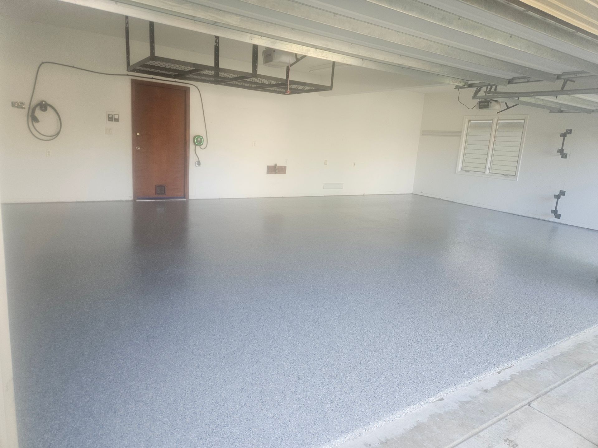 An empty garage with a gray floor and white walls.
