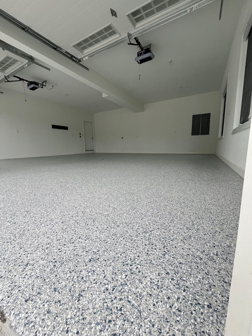 A garage with a gray floor and white walls.