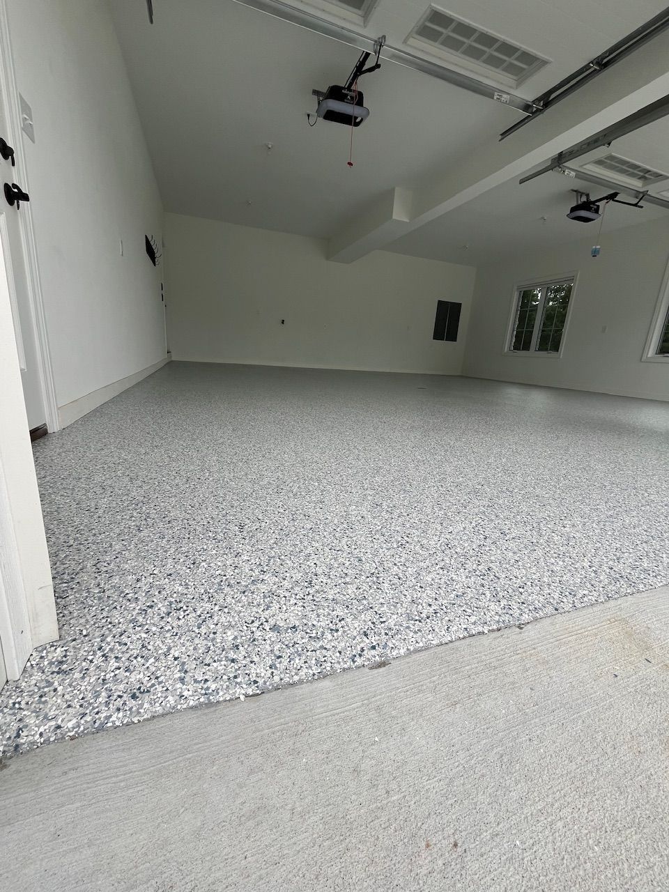 A garage with a gray floor and white walls.