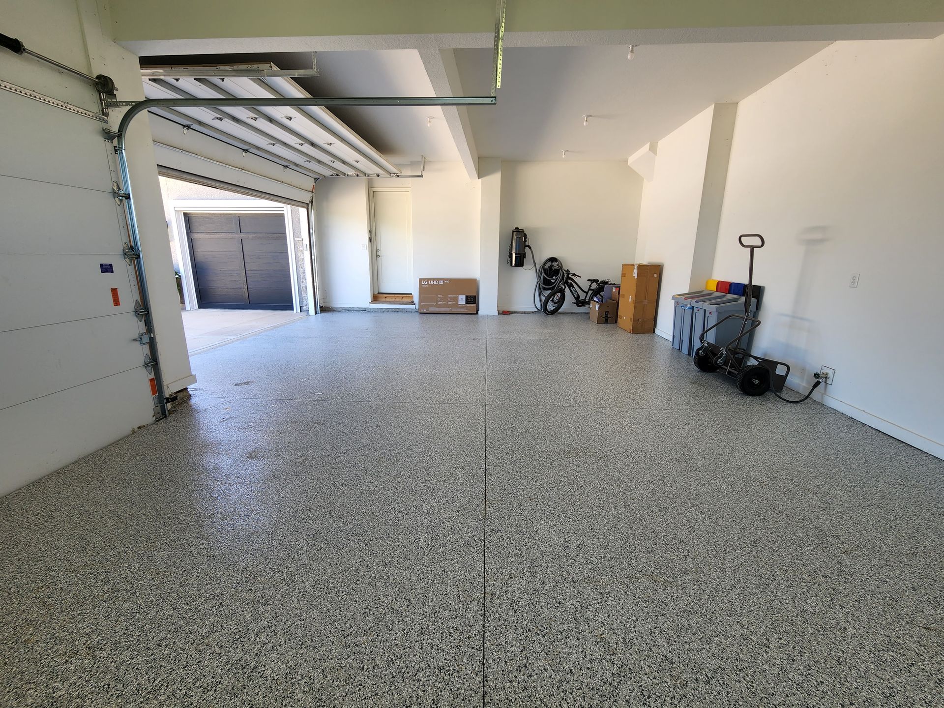 A large empty garage with a garage door open.