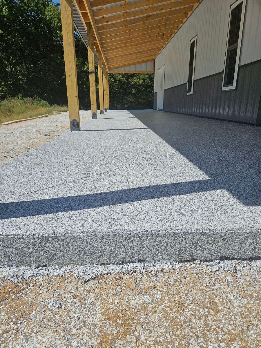 A concrete walkway leading to a house with a wooden roof.