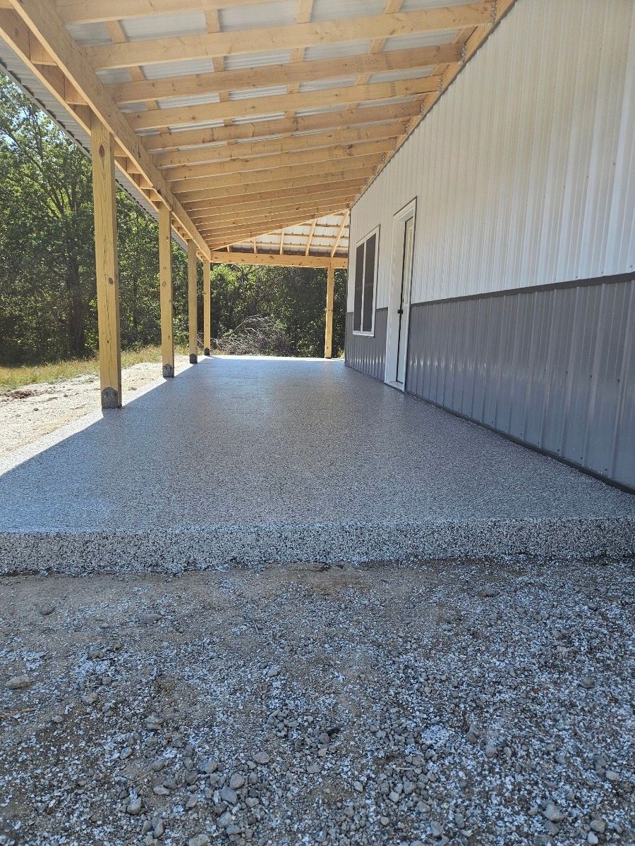 A concrete walkway leading to a house with a wooden roof.