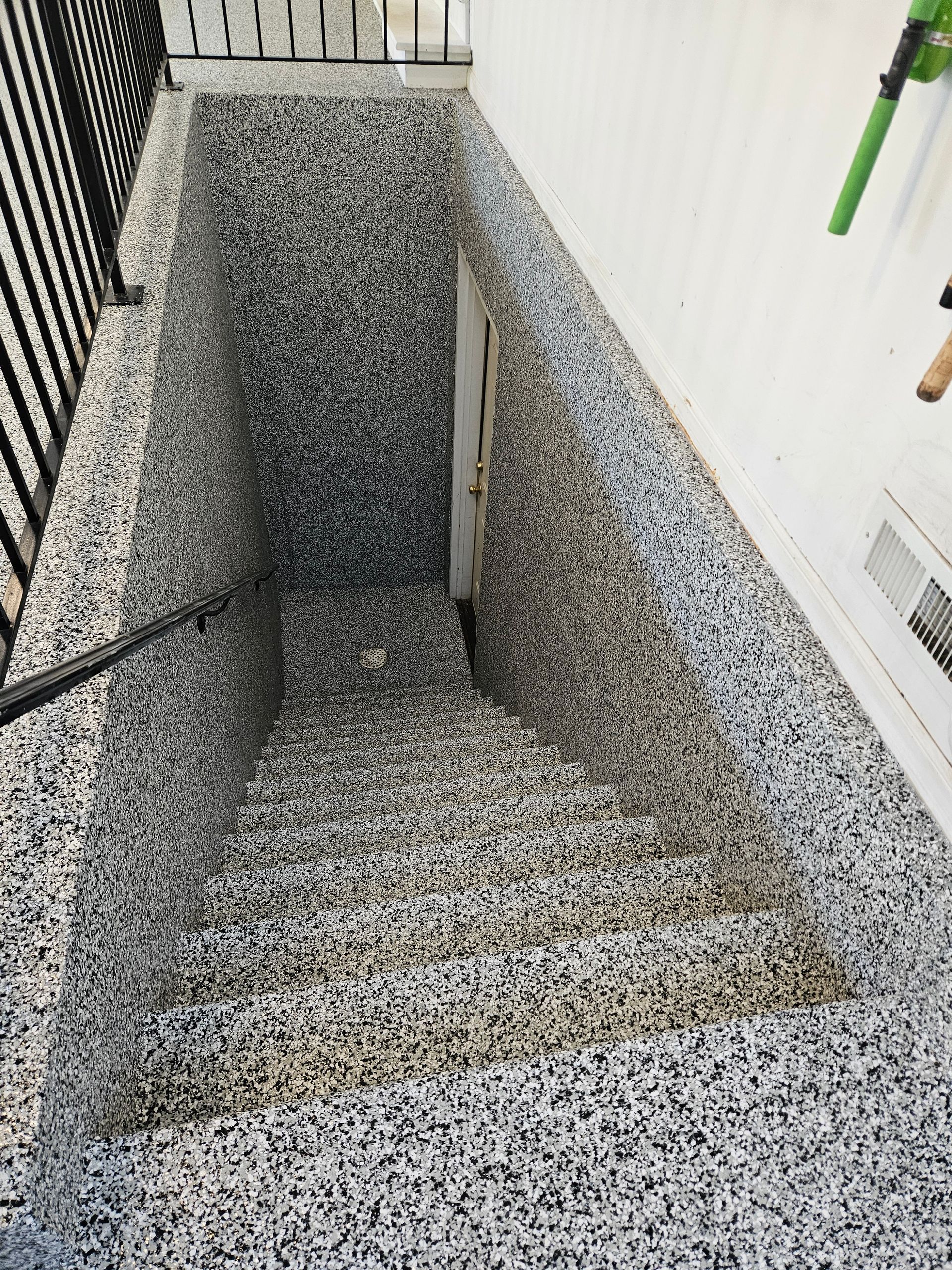 A staircase leading up to a basement with a fence in the background.