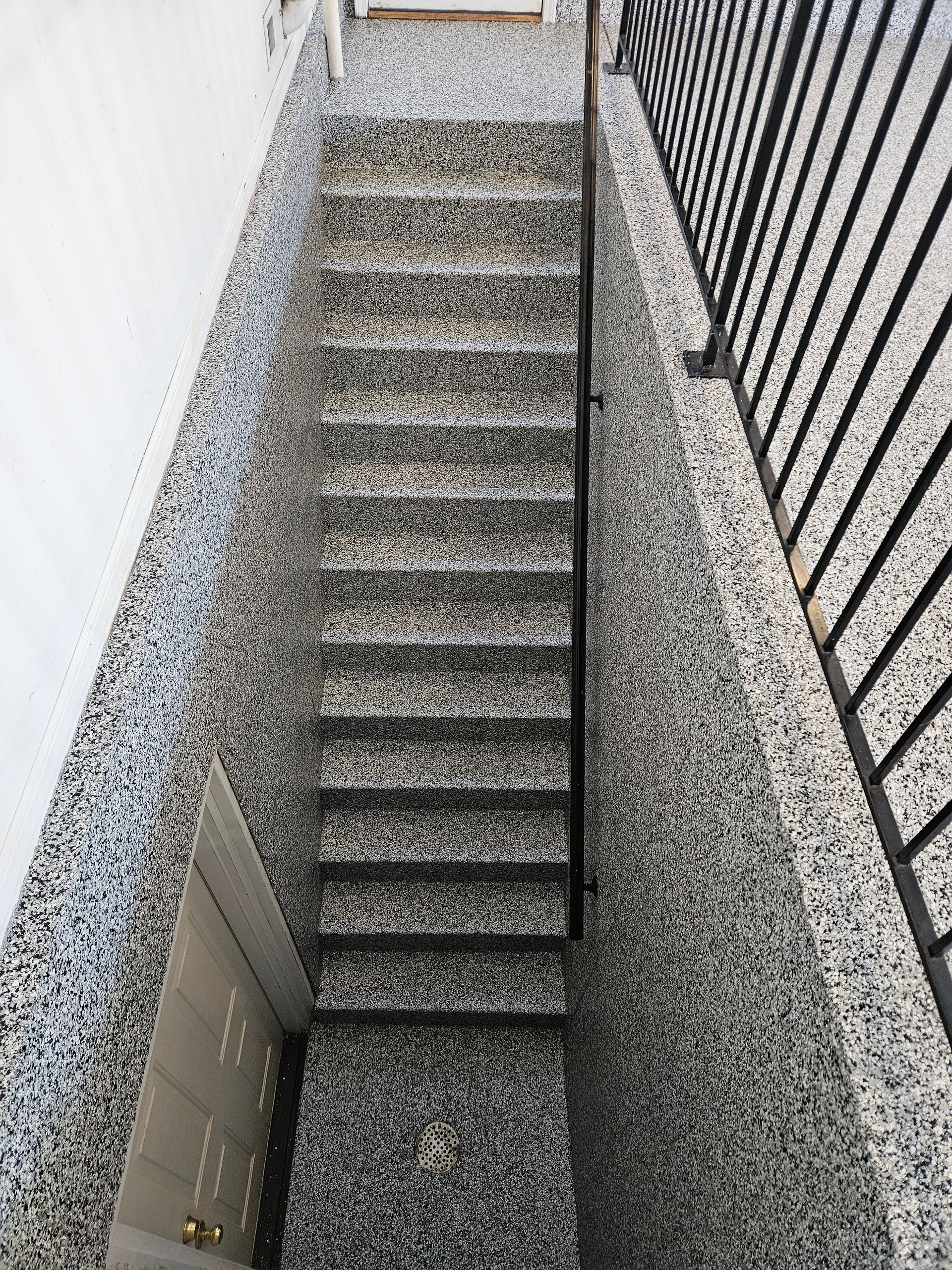 A set of stairs leading up to a balcony with a metal railing.