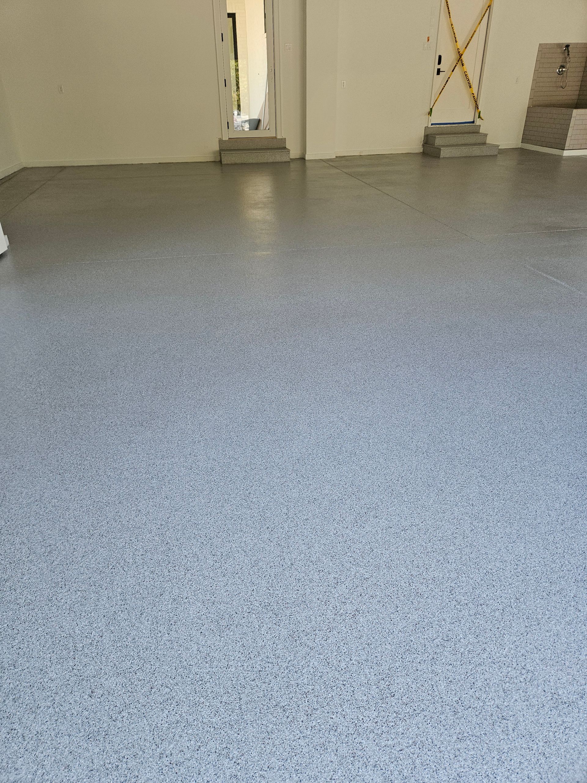 A garage with a gray floor and white walls.