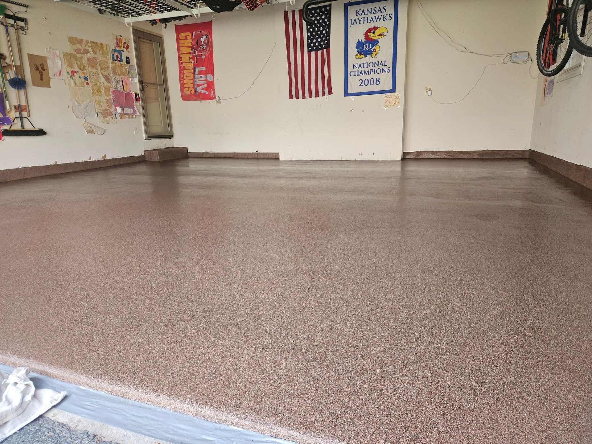 A garage with a concrete floor and a flag on the wall.