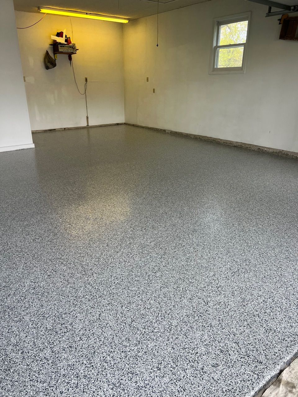 A garage with a gray floor and white walls.