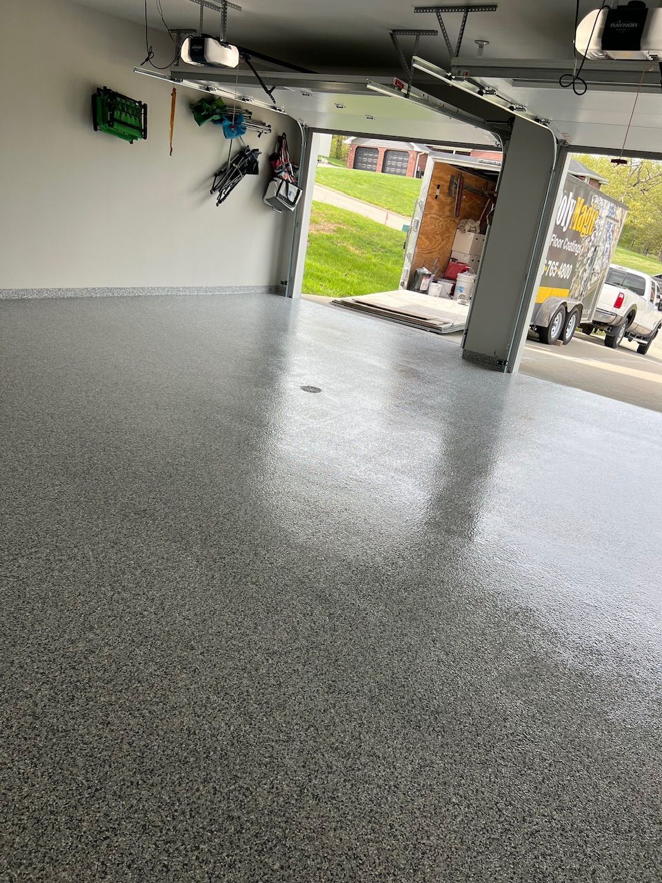 A garage with a gray floor and a white wall.