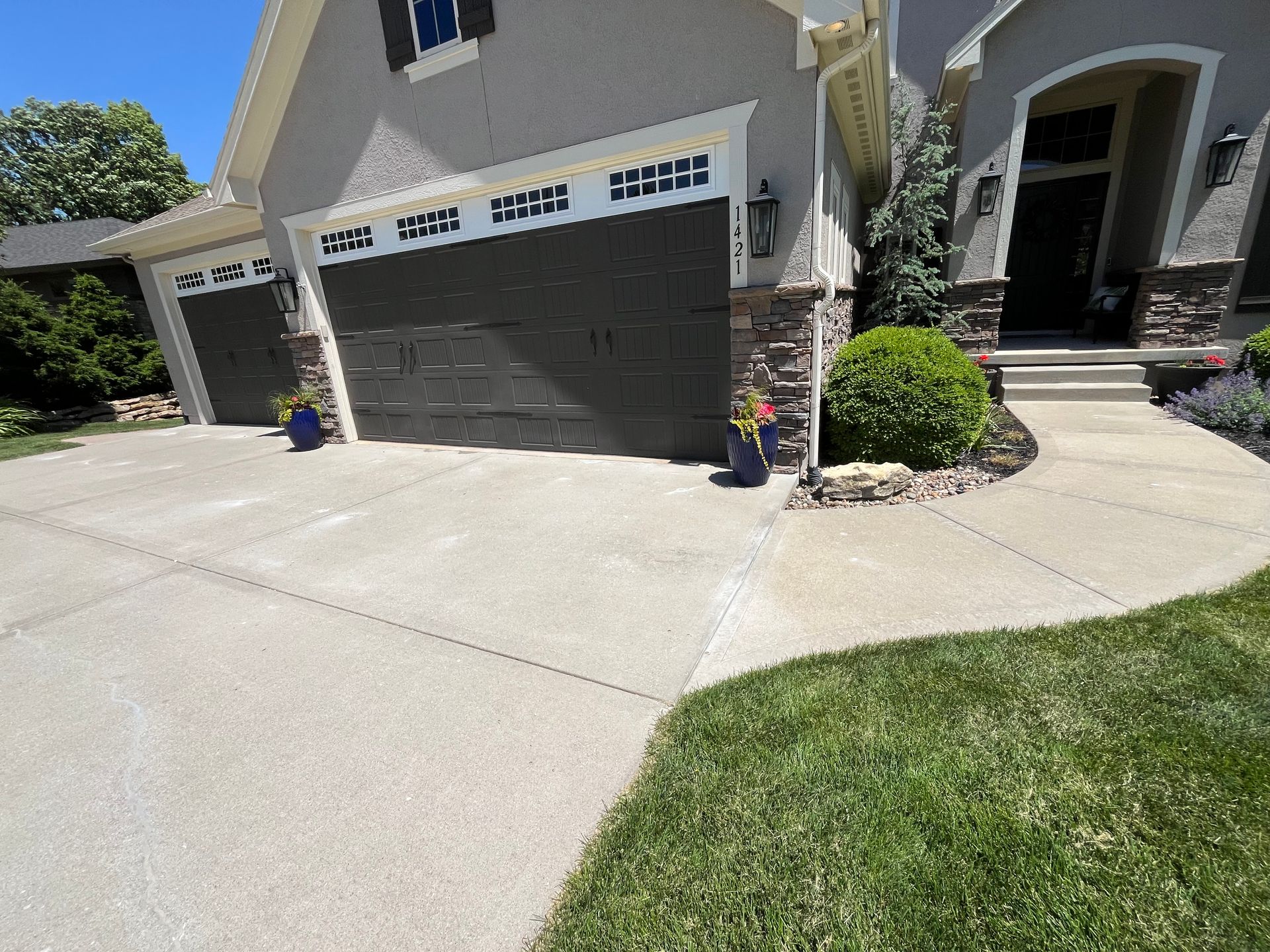 A house with two garage doors and a walkway leading to it
