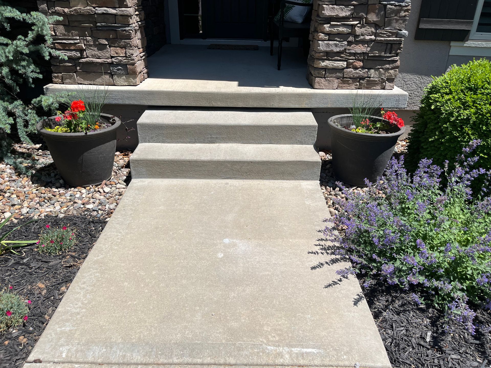 A concrete walkway leading to the front door of a house