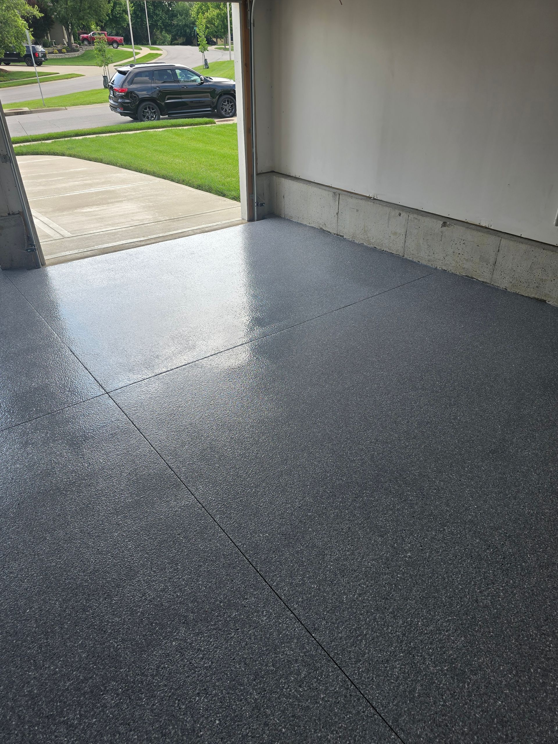 A car is parked in a garage with a shiny floor.