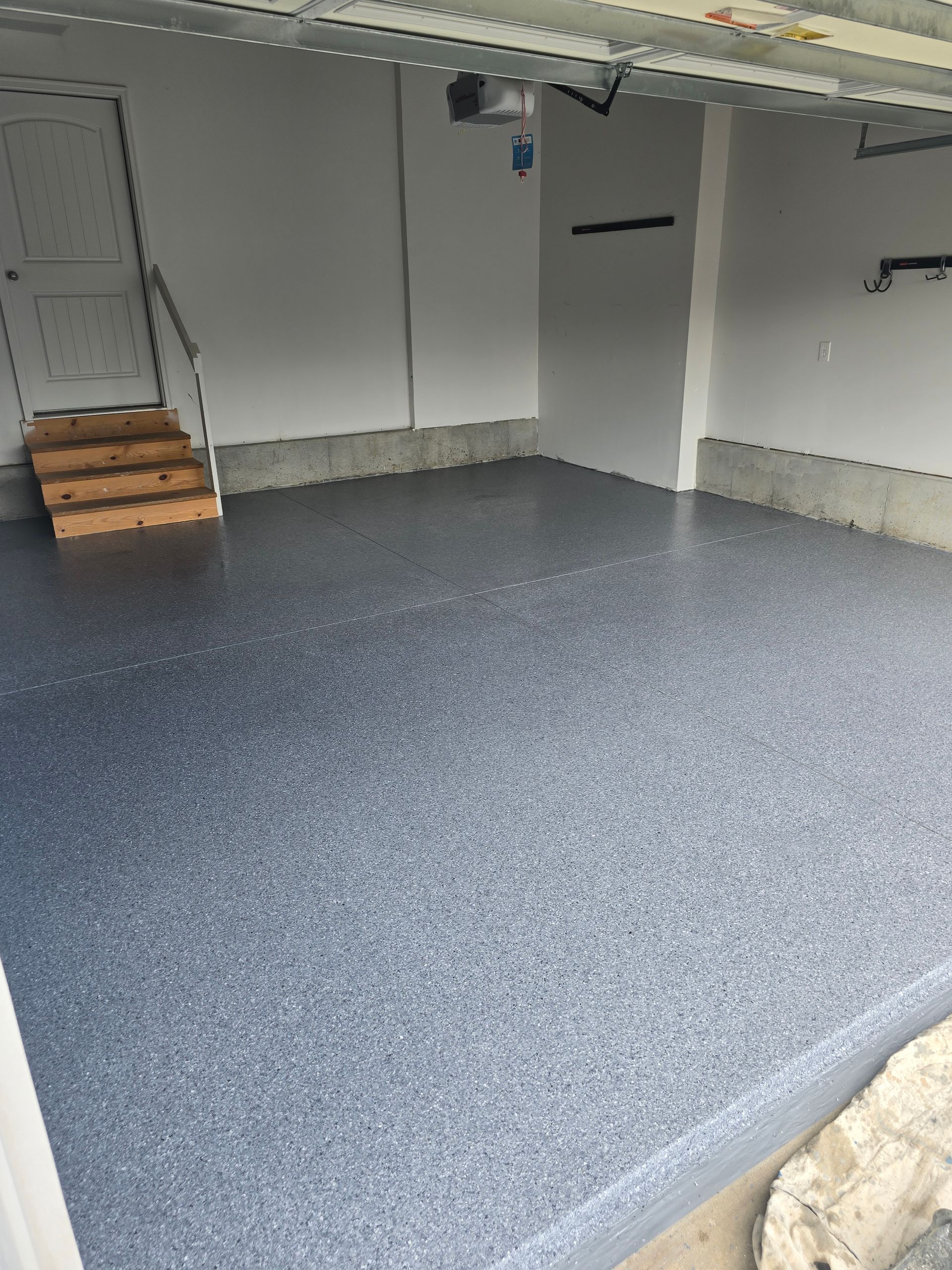 A garage with a gray floor and stairs.