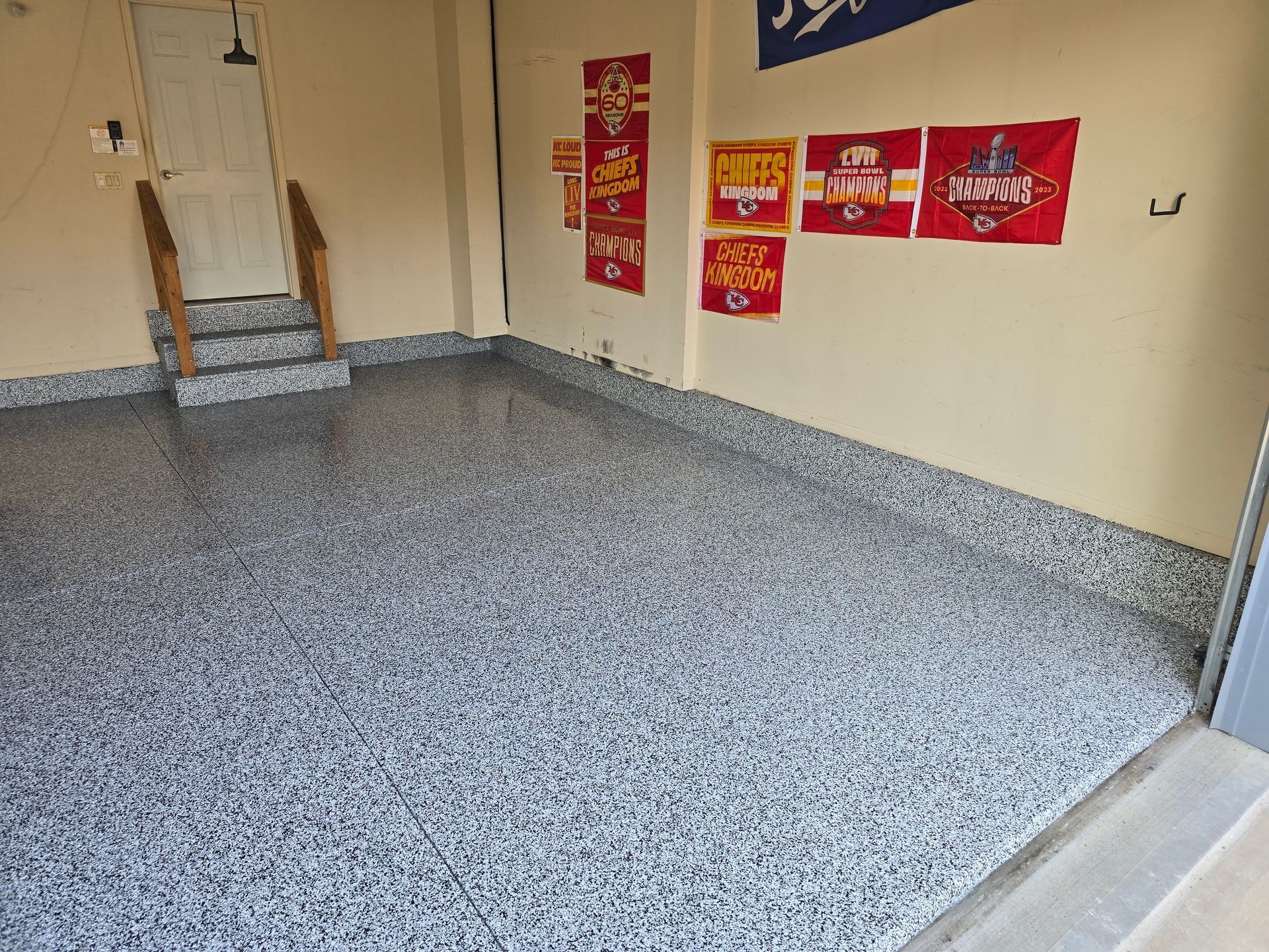 A garage with a staircase and a few posters on the wall