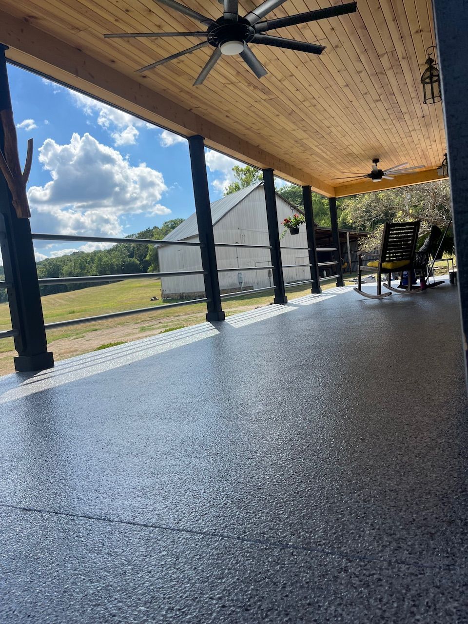 A porch with a screened in area and a concrete floor.