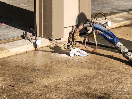 A hose is laying on the ground next to a door.