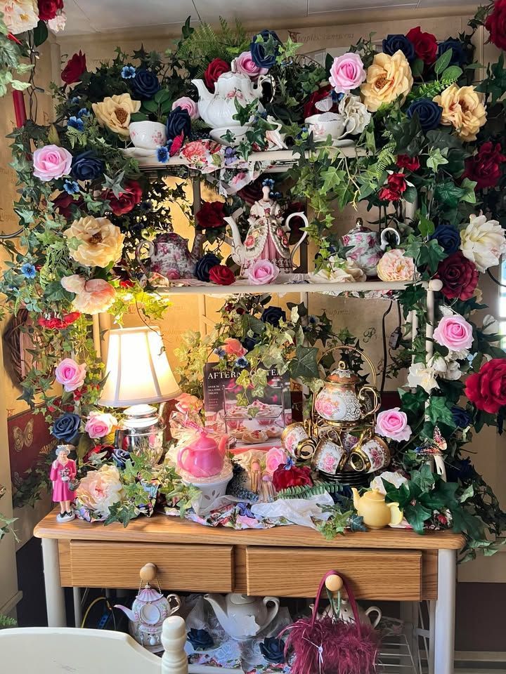 Wooden cabinet overflowing with colorful flowers and teacups.