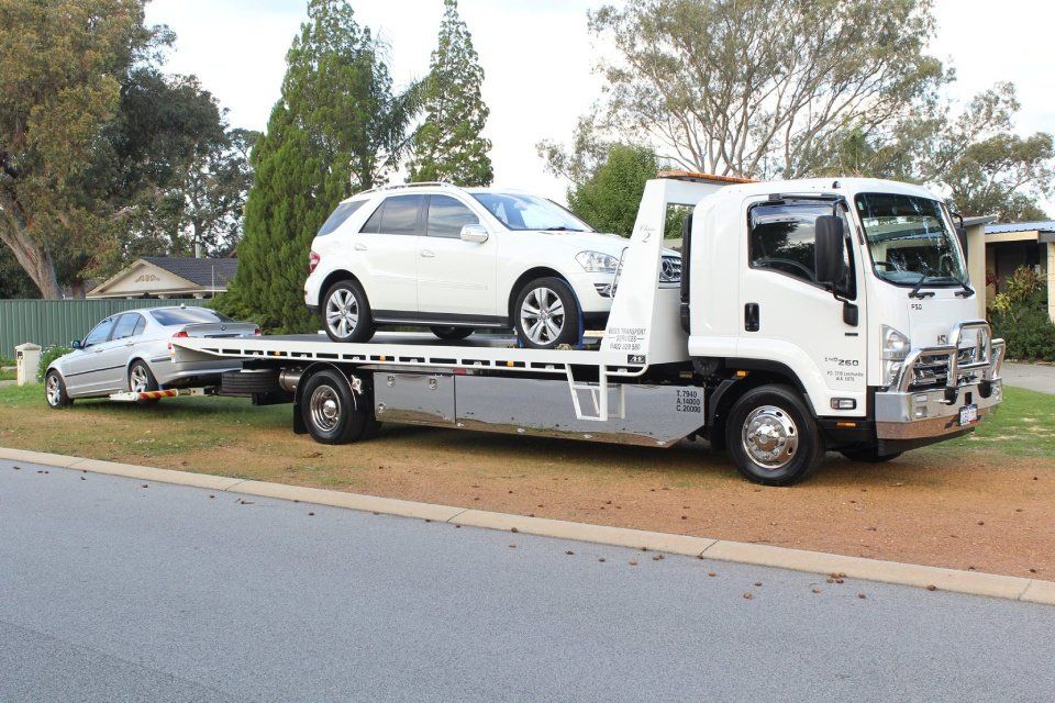white colour car on a flat bed transportation truck