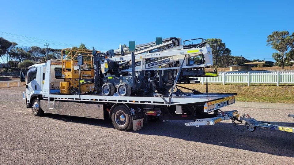 side view of cars on a tow truck for transportation