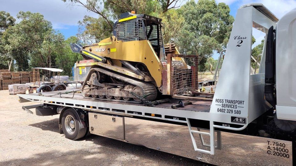 yellow forklift crane being transported