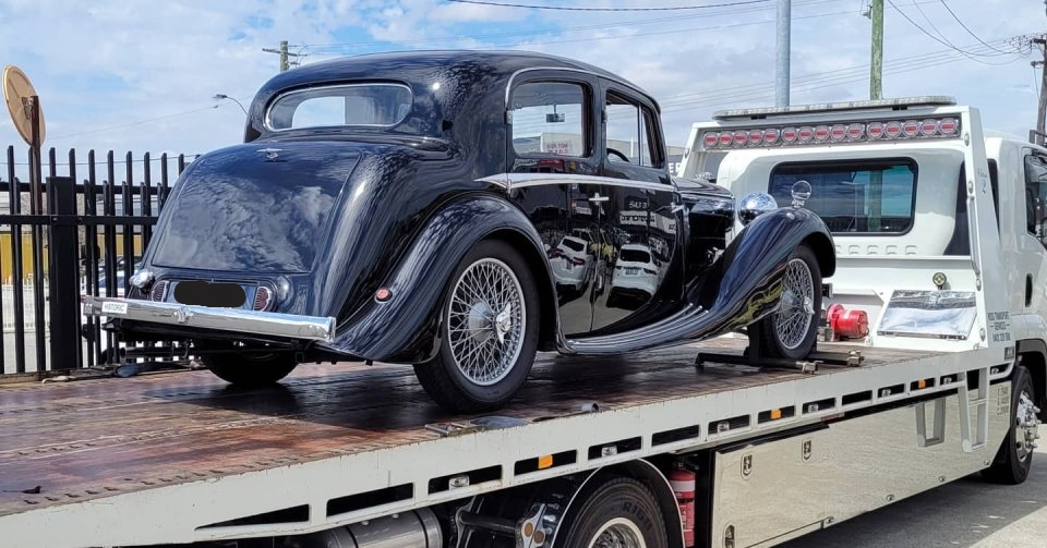 old classic black car being transported