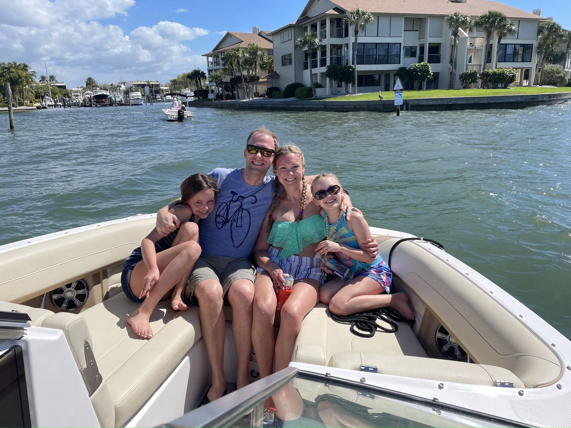 A group of people are sitting on a pontoon boat in the ocean.