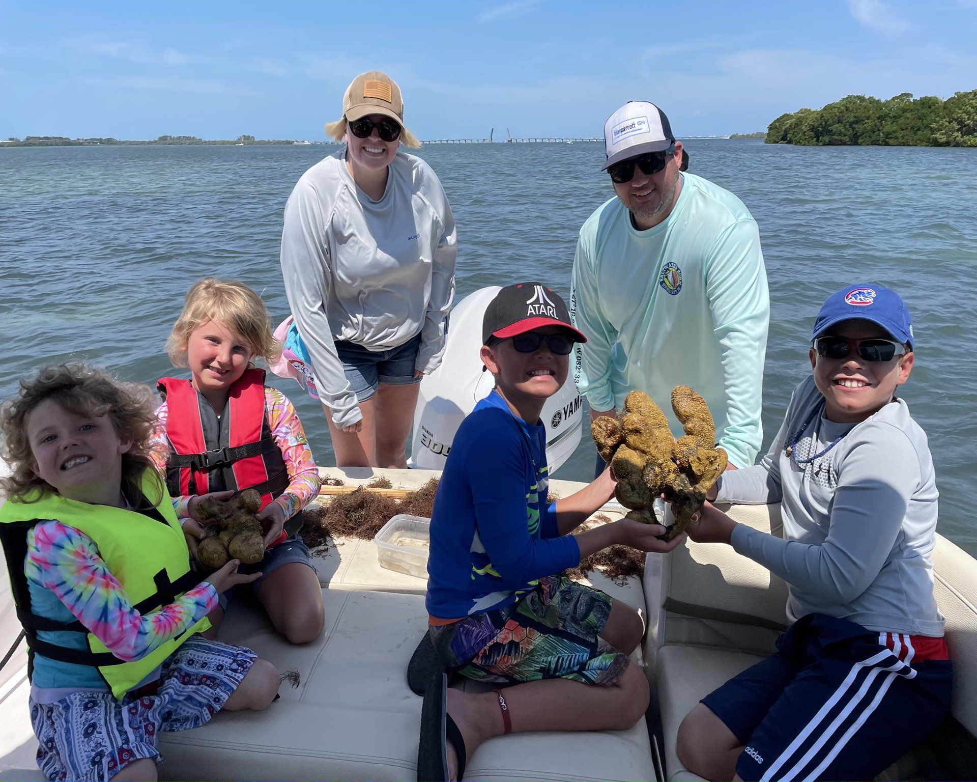 Children holding aquatic sponges with their parents