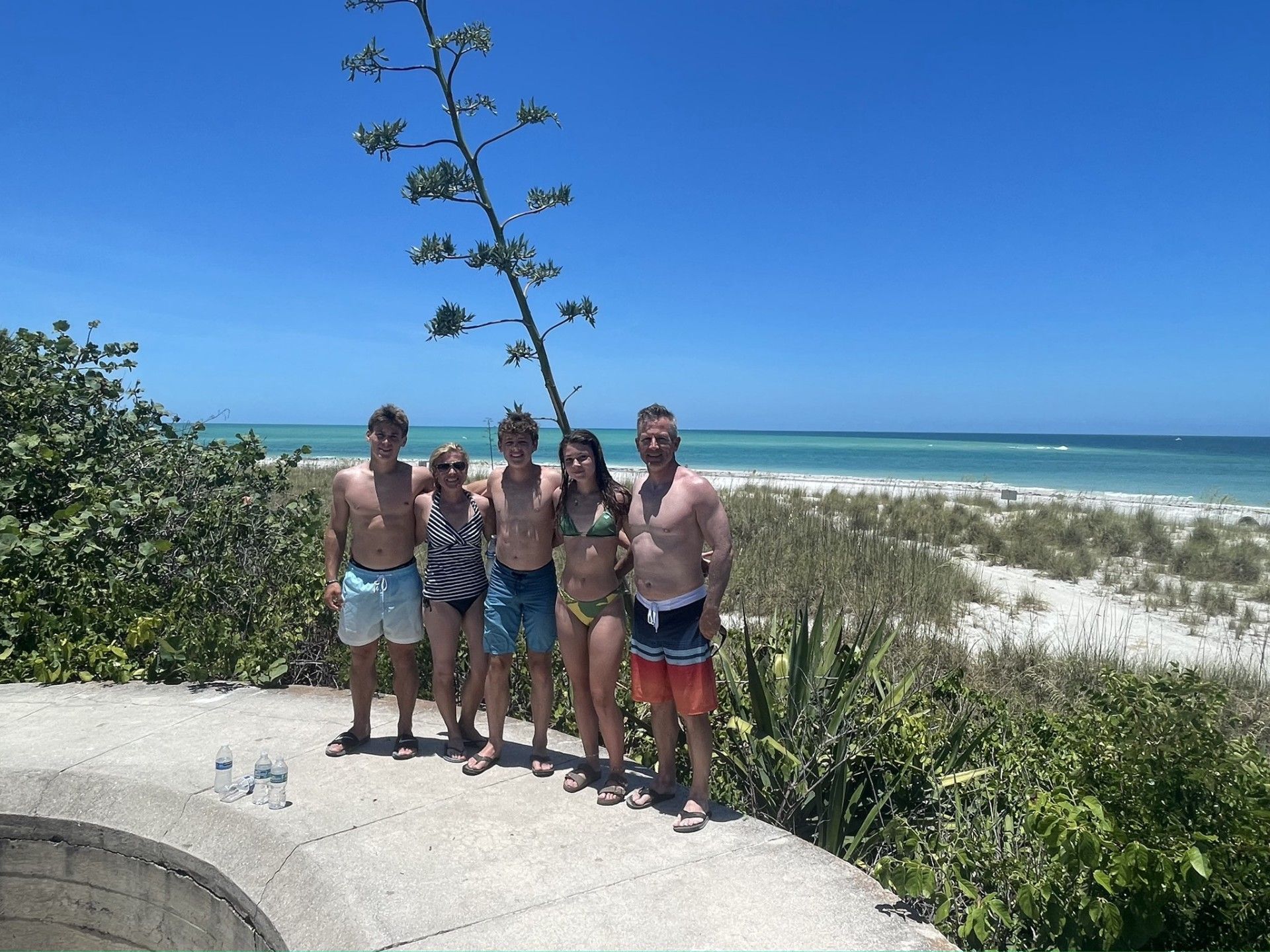 A group of people posing for a picture on a beach