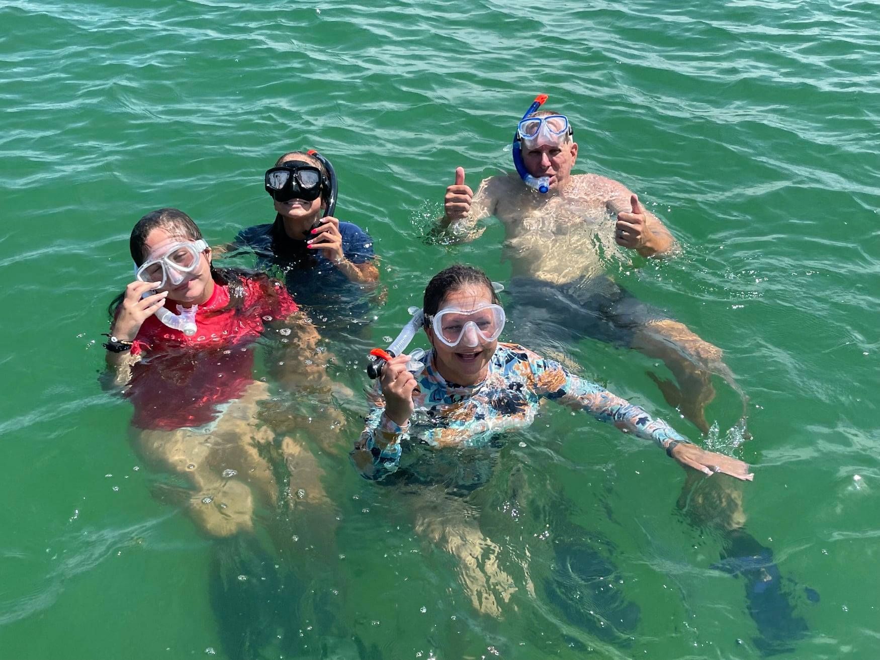 4 people snorkeling in clear florida water